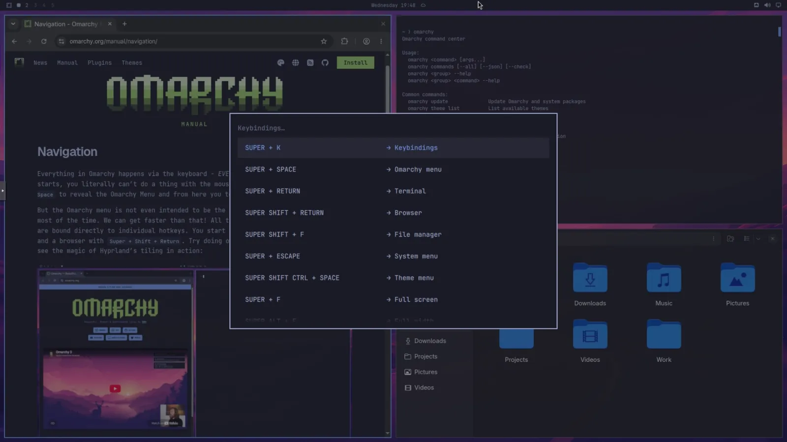 Omarchy Linux showing tiled windows, workspaces and keyboard shortcut reference